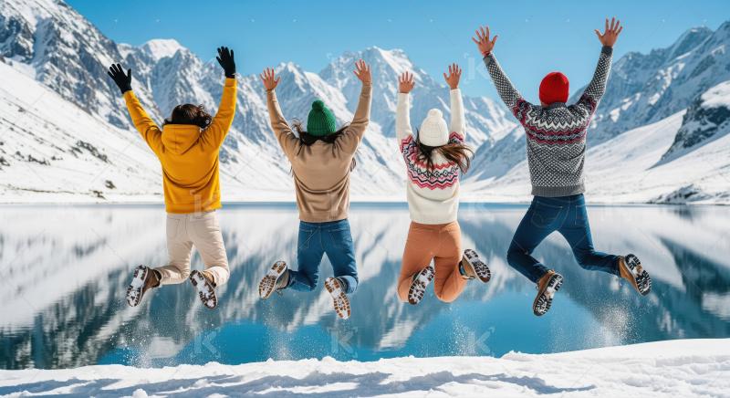 Group of friends dressed in colorful winter clothing joyfully ju
