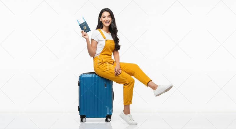 Young woman smiling, ready for travel with passport and suitcase