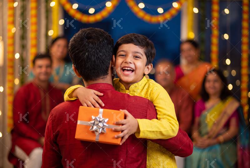 Happy indian father and son holding gift box on traditional diwali festival