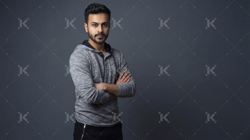 Confident Young Man in Grey Hoodie, Arms Crossed