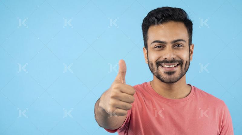 Happy Young Man Gives Thumbs Up, Expressing Positivity