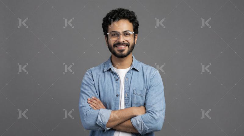 Happy Young Indian Man with Glasses and Crossed Arms
